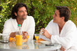Two men eating breakfast in the garden