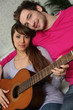 Girl and boy with guitar sitting on a couch Girl and boy with guitar sitting on a couch