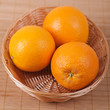 Three in wicker basket of oranges