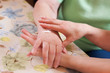 Altenpflegerin cremt Seniorin die Hand