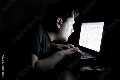 Photo: Man working on laptop in the dark Man working on laptop in the dark