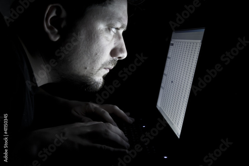 Photo: Man working on laptop in the dark Man working on laptop in the dark
