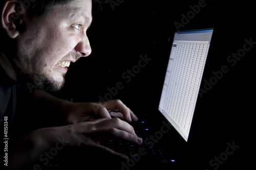 Photo: Man working on laptop in the dark Man working on laptop in the dark