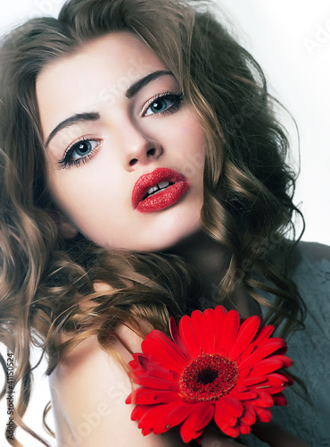 Photo: Portrait sexy woman with sensual lips and beautiful red flower Portrait sexy woman with sensual lips and beautiful red flower
