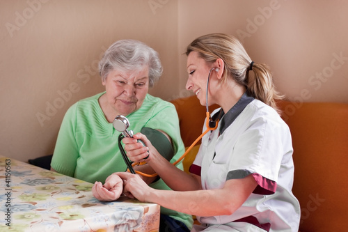 Photo: Altenpflegerin misst Blutdruck bei Seniorin Altenpflegerin misst Blutdruck bei Seniorin