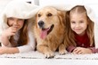 Cute little girls having fun with dog smiling