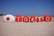 Tokyo, name on painted pebbles with sand background