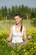 Portrait of a girl in the flower meadow. Woman meditating
