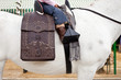 Detail of a little girl riding a horse on a spanish saddle