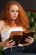 Photo: Beautiful redhead reading a bible Beautiful redhead reading a bible