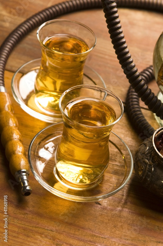 Foto: Cup of turkish tea and hookah served in traditional style Cup of turkish tea and hookah served in traditional style