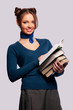 girl standing with a bunch of books