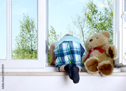Photo: Junge beugt sich aus dem Fenster Junge beugt sich aus dem Fenster