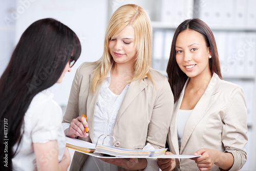 Foto: drei junge frauen im büro drei junge frauen im büro