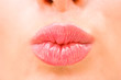 Foto: Young woman kissing lips Young woman kissing lips