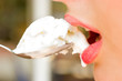 Close-up of pretty woman lips with icecream in the spoon