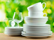 Clean dishes on wooden table on green background