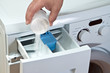 Man pours detergent into the washing machine