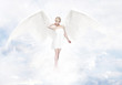 Gorgeous young blond woman as angel in heaven