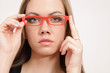 Hübsche, junge Frau mit roter Brille