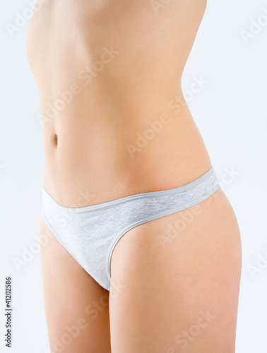 Foto: Slim tanned woman's body isolated over gray background. Healthy Slim tanned woman's body isolated over gray background. Healthy