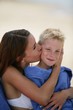 Photo: Woman kissing her son on a beach Woman kissing her son on a beach