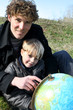 Father and son looking at a globe