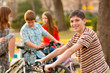 Happy teenage boy spending time with his friends riding bicycles