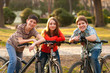 Two teenage boys and one teenage girl having fun on bicycles