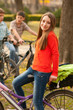 Cute happy teenage girl riding bicycles with her friends