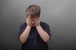 Trauriger Junge mit Hand vor dem Gesicht
