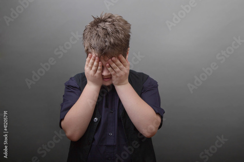 Foto: Trauriger Junge mit Hand vor dem Gesicht Trauriger Junge mit Hand vor dem Gesicht