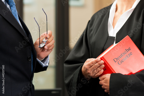 Photo: Anwältin mit Gesetzbuch und Mandant Anwältin mit Gesetzbuch und Mandant