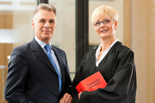 Foto: Anwältin mit Gesetzbuch und Mandant Anwältin mit Gesetzbuch und Mandant