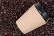 Takeaway coffee cup on arabica beans