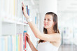 pretty female college student studying in the university library
