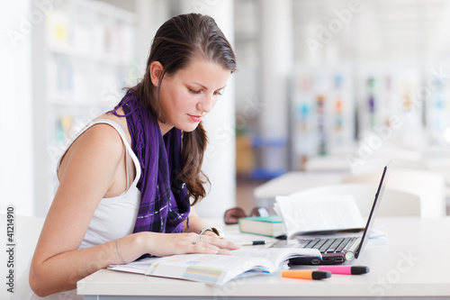 Photo: pretty female college student studying in the university library pretty female college student studying in the university library