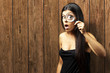 Young woman surprised looking through a magnifying glass against Young woman surprised looking through a magnifying glass against
