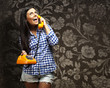 portrait of young woman talking on vintage telephone against a v
