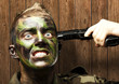 portrait of young soldier comiting suicide against a wooden wall