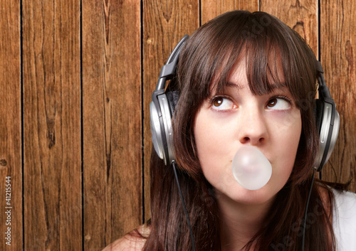 Photo: portrait of young woman listening to music with bubble gum again portrait of young woman listening to music with bubble gum again