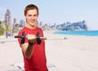 portrait of young man with weights in against a beach portrait of young man with weights in against a beach