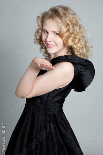 Foto: Young blonde girl blowing a kiss and posing in studio Young blonde girl blowing a kiss and posing in studio