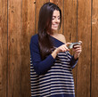 portrait of young woman touching a modern mobile against a woode portrait of young woman touching a modern mobile against a woode