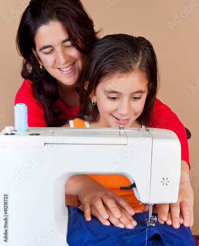 Photo: Latin mother and daughter sewing together Latin mother and daughter sewing together