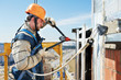 Worker builders at facade tile installation Worker builders at facade tile installation