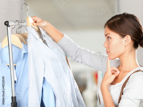 Photo: Shopper choosing clothes thinking Shopper choosing clothes thinking
