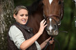 young woman caressing a horse