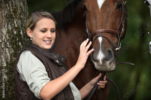 Foto: young woman caressing a horse young woman caressing a horse