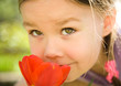 Portrait of a cute little girl smelling flowers